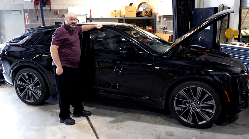 Photo of Jonathan Hankey standing in front of a black car in a garage
